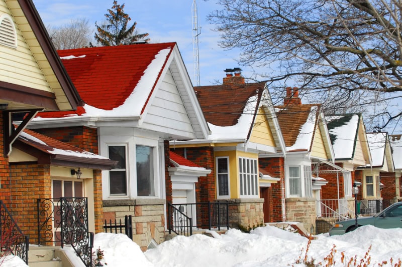 Prepping Your Plumbing for Winter. Row of residential houses in winter with snow.